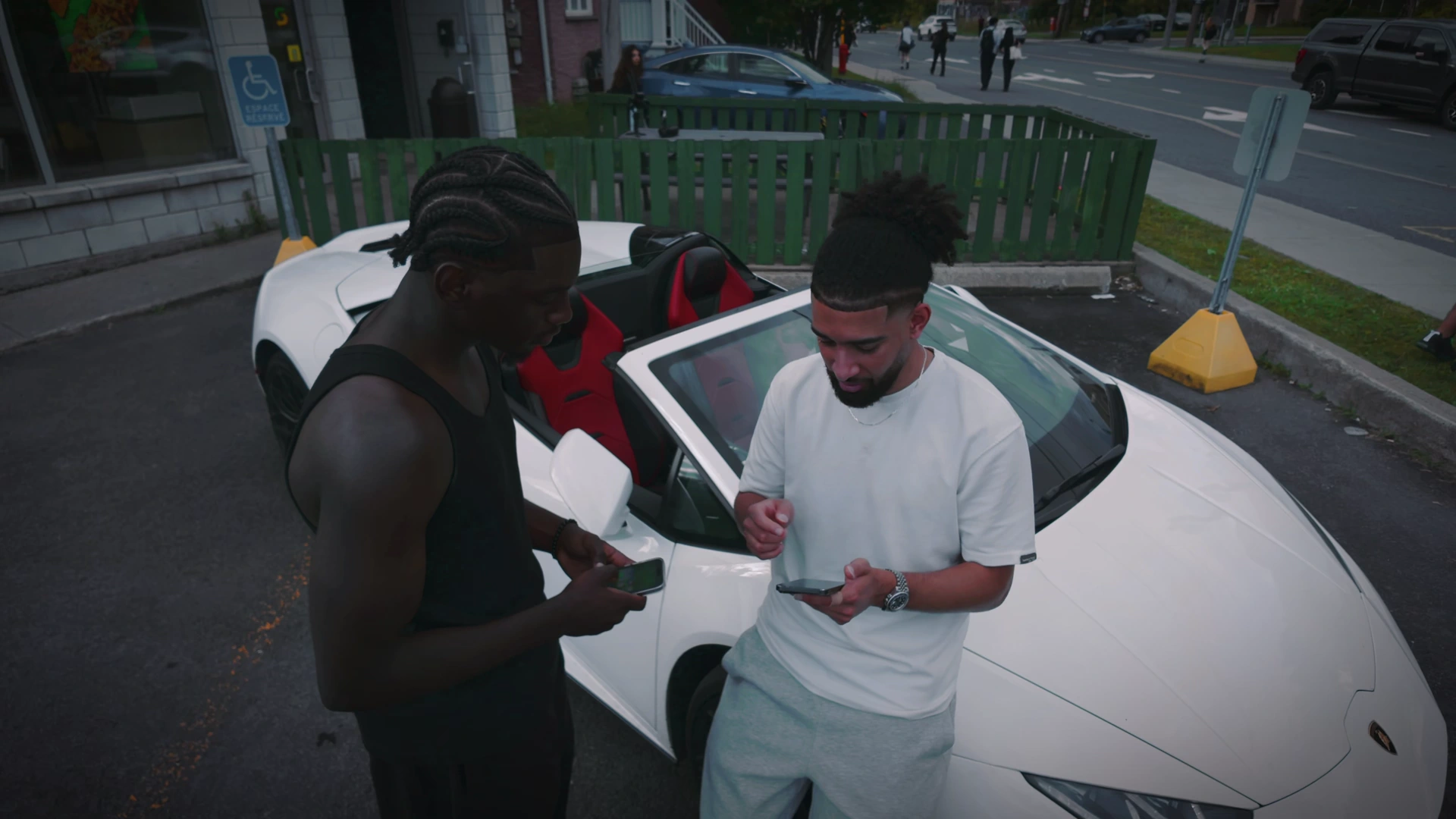 Infinite — téléphone en main près de la Lamborghini